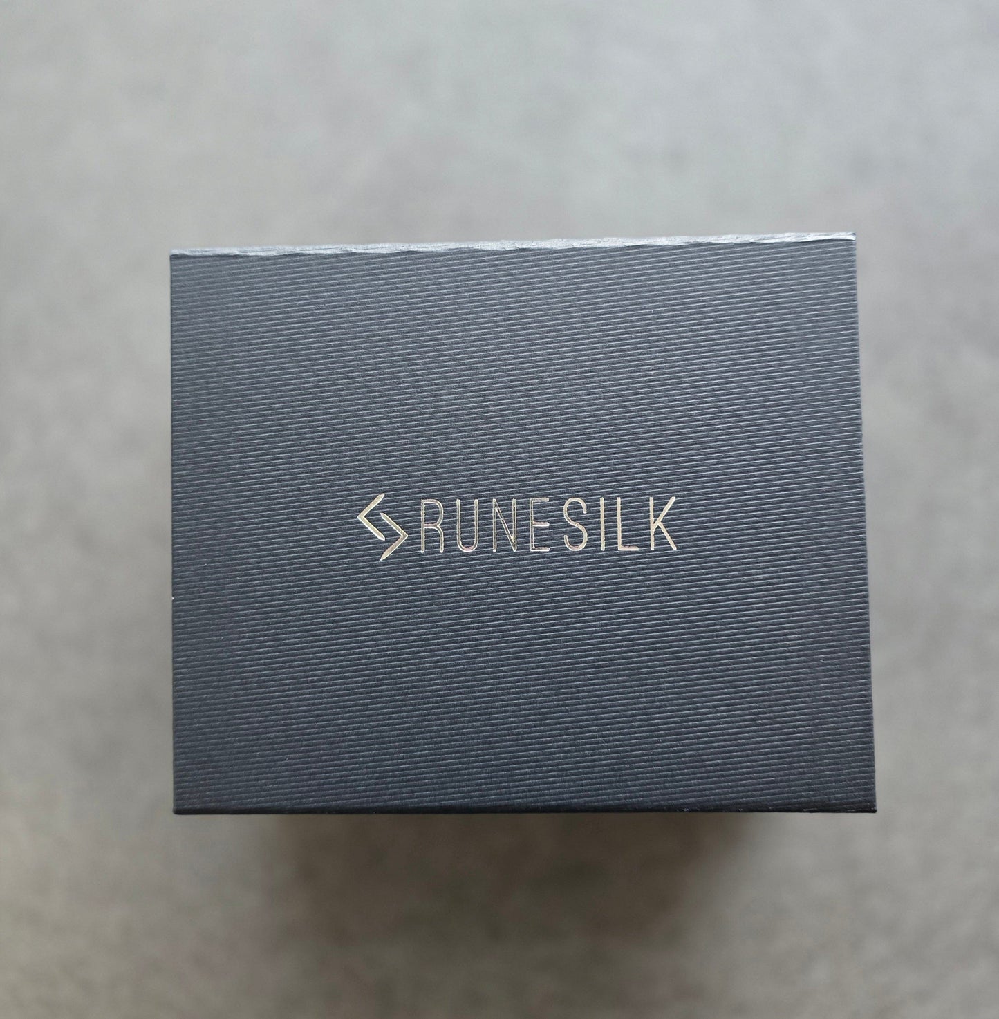 Runesilk beard oil sample gift box on a gray background